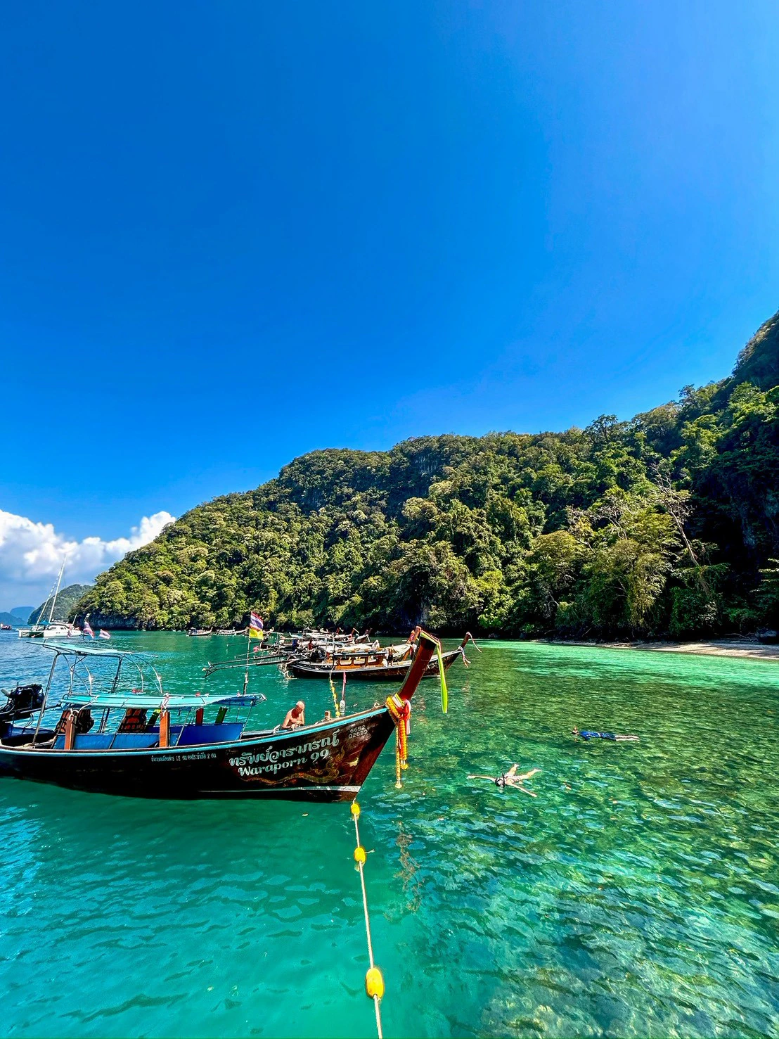 เรือหางยาวและน้ำทะเลใสสีเขียวมรกตที่เกาะห้อง กระบี่