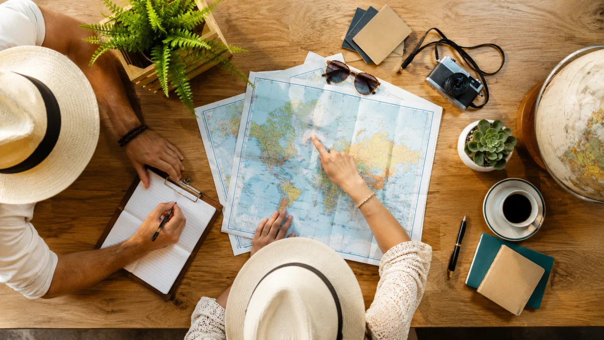 A couple planning their trip together over a world map